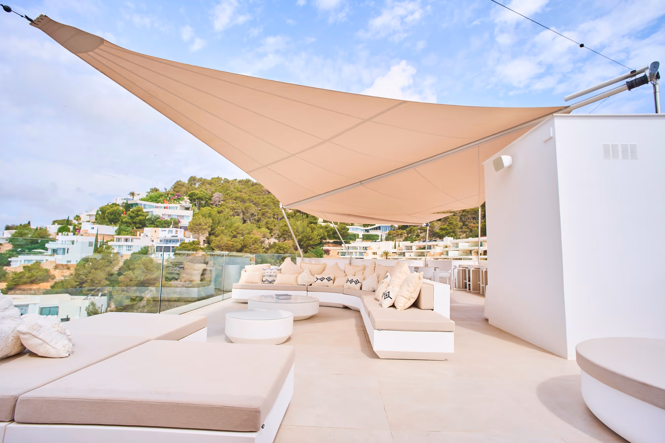 SunSquare® Kompensator-Anlage mit 49 m² Segelfläche auf einer Dachterrasse an der Küste – eleganter Sonnenschutz mit Meerblick.