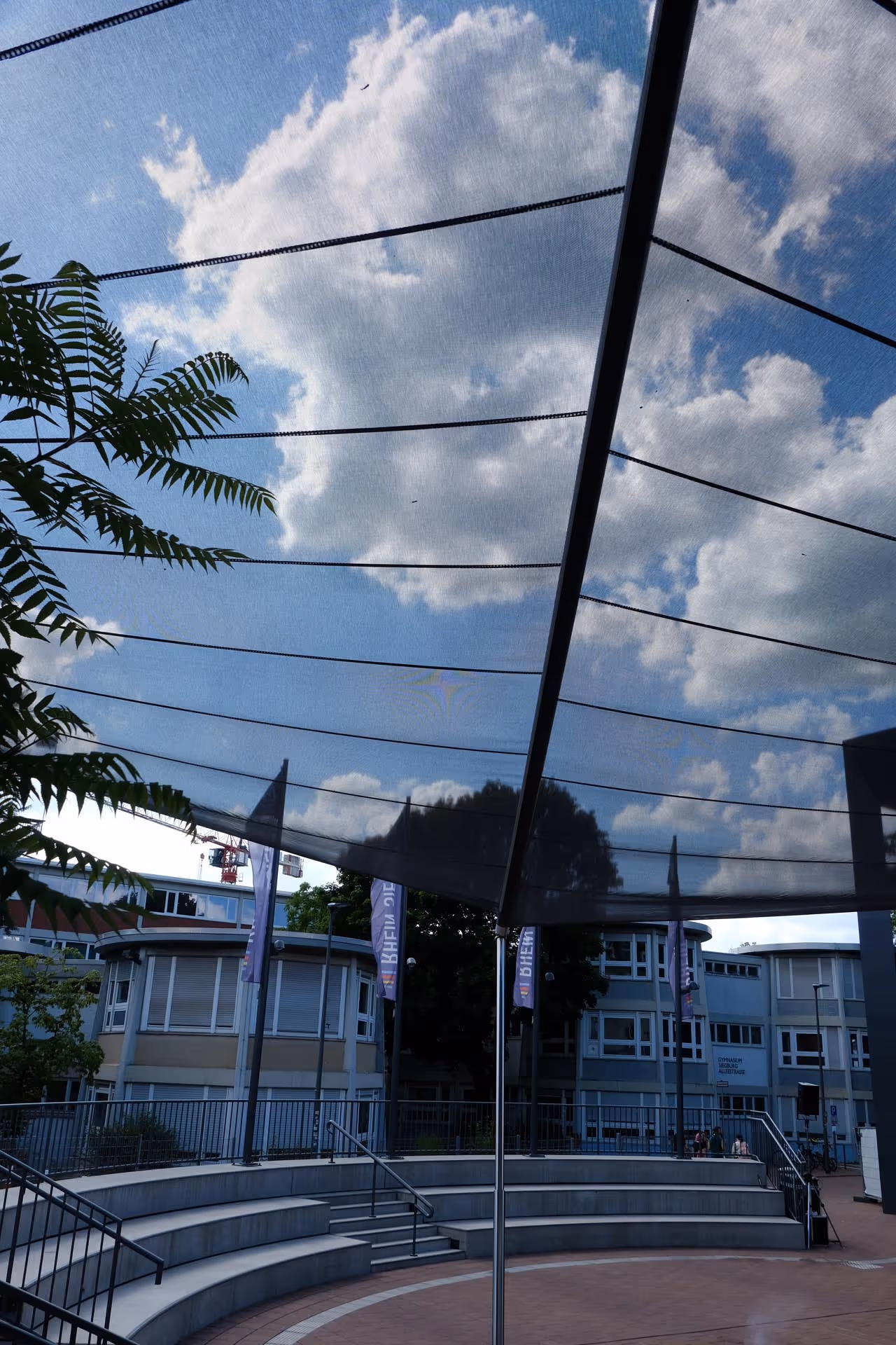 Ringförmige Stufenanlage des Rhein-Sieg-Forums mit SunSquare-Segeln – 220 m² textile Beschattung für öffentliche Veranstaltungsfläche.