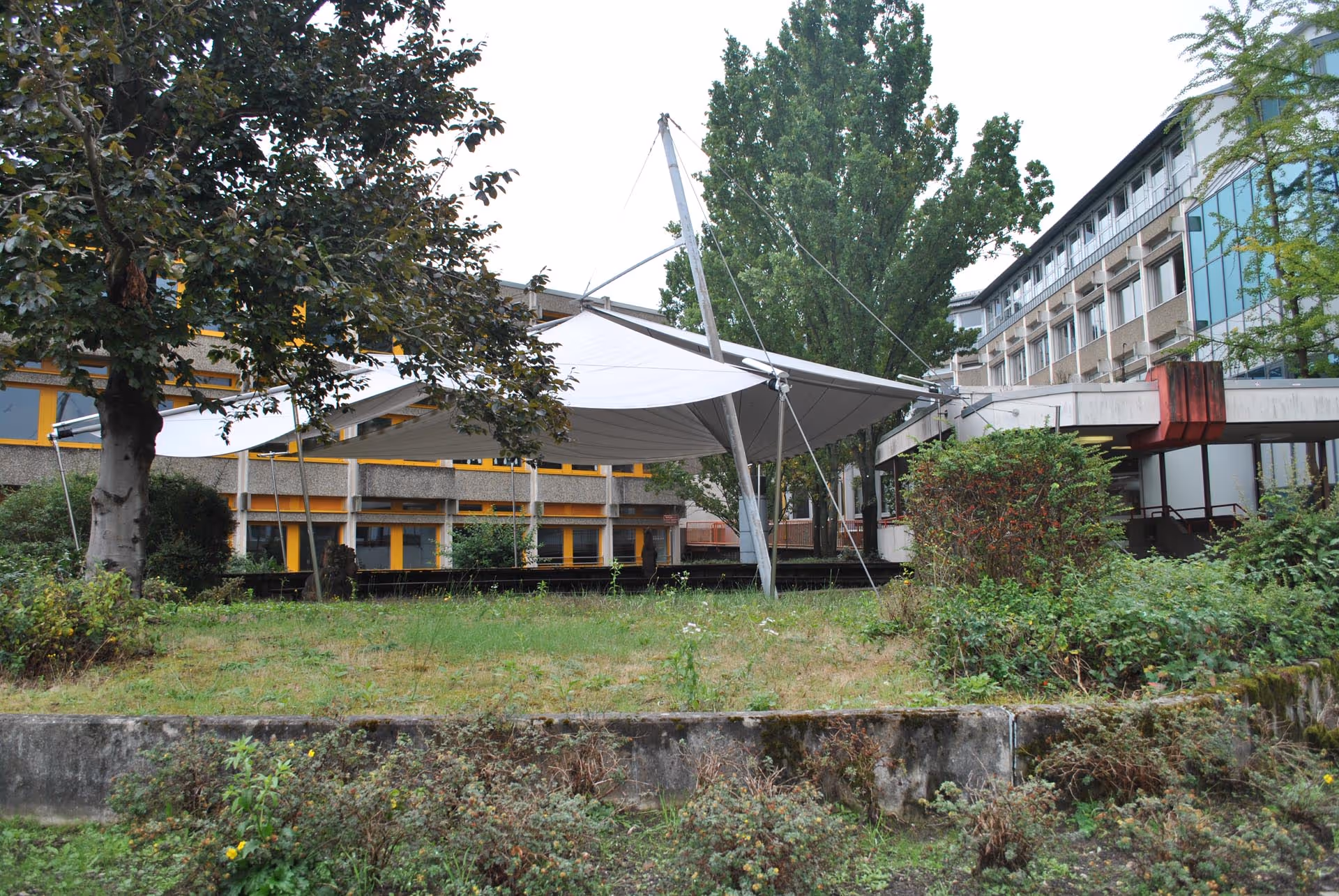 Ein Blick von der Ferne zu der Zeltartigen Forumsgestaltung mit SunSquare Sonnensegeln.