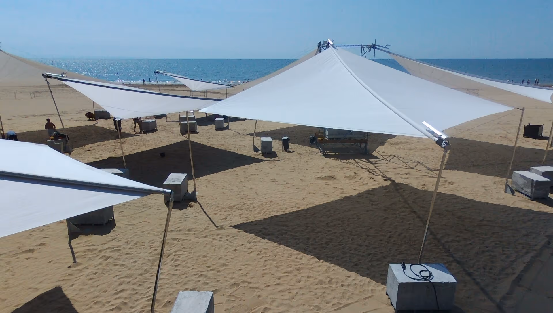 SunSquare Sonnensegel montiert auf beweglichen Betonfundamenten für Musikfestival.