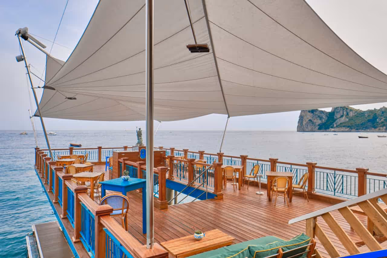 Zwei 70 m² große SunSquare-Segel aus Orchestra-Gewebe – stilvoller Schutz direkt am Meer.