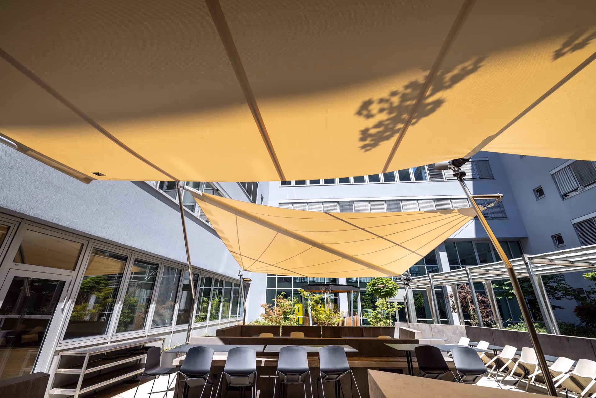 Innenhof mit SunSquare® Beschattungssystem – angenehme Atmosphäre für Mitarbeitende