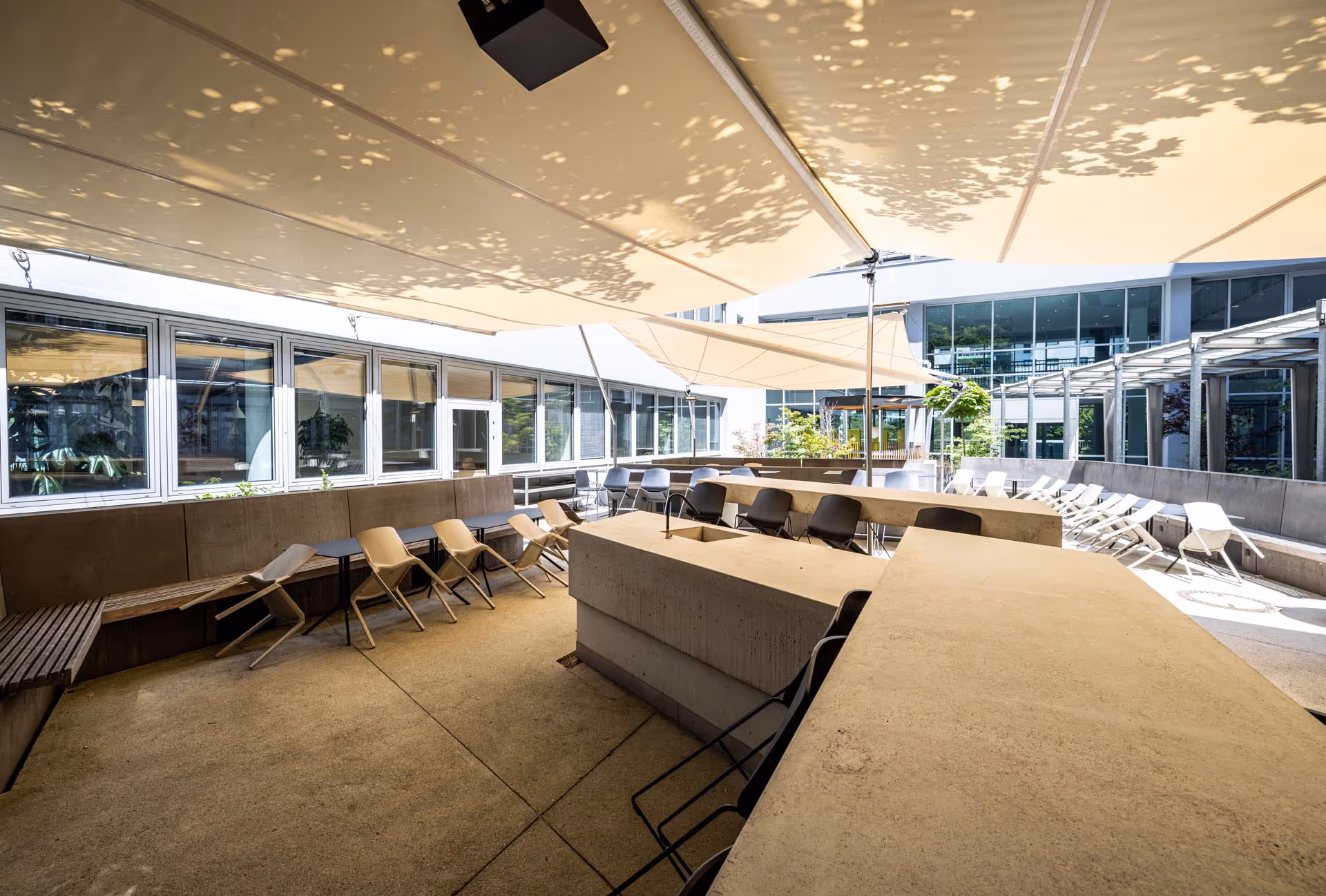 Innenhof mit SQK-I und AX-II SunSquare® Sonnensegeln – funktionale Architektur trifft Komfort