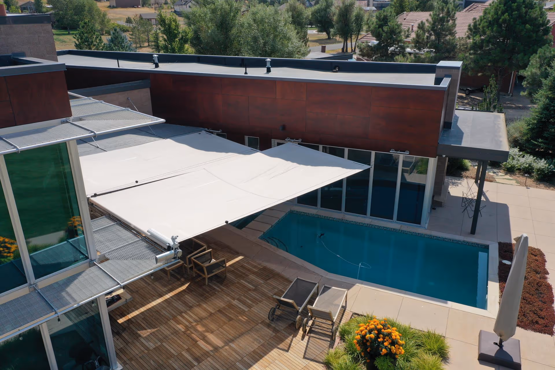 Two single-sided rectangular sails span a kind of courtyard, protecting the seating area and parts of the pool.
