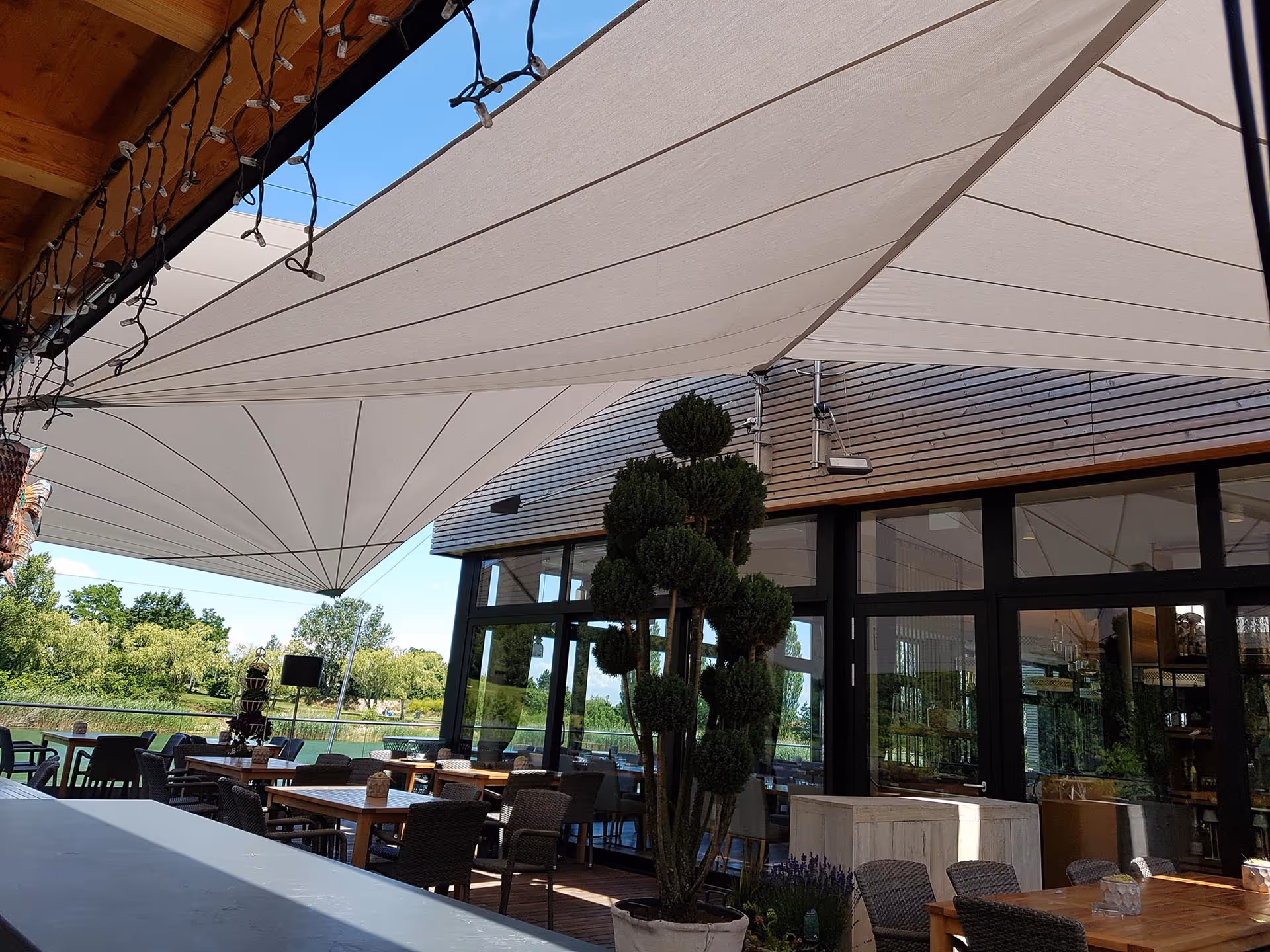 Terrassenbereich des Restaurants Südufer mit zwei SunSquare Anlagen für Sonnen- und Regenschutz.