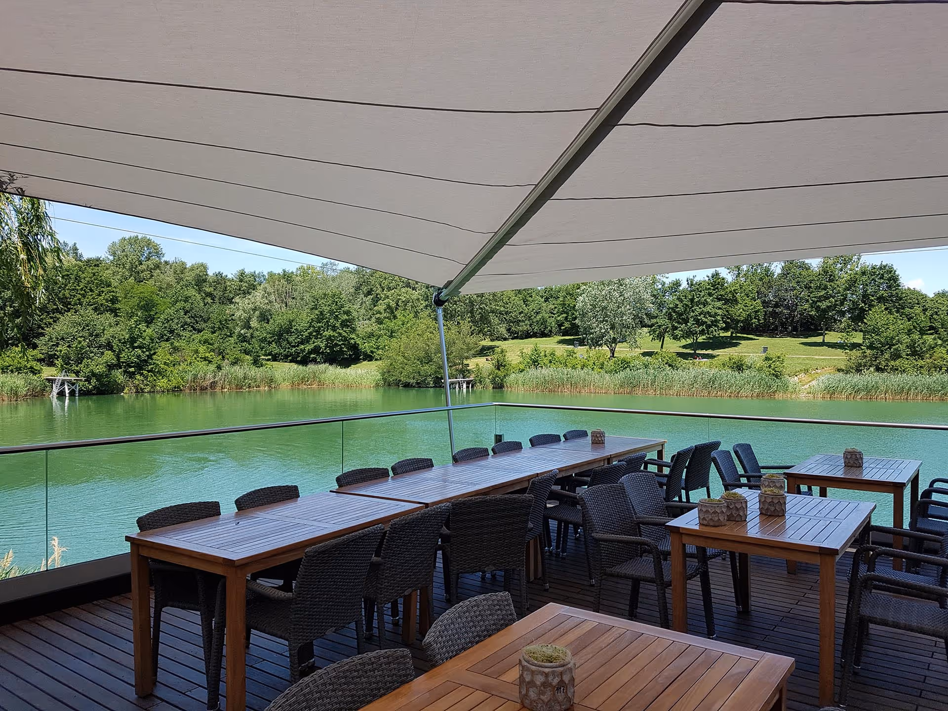 Stimmungsvolle Atmosphäre unter den SunSquare Segeln – direkt am idyllischen Schotterteich.