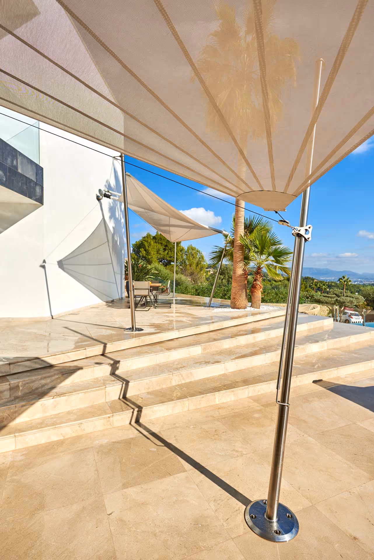 Hochwertige SunSquare-Segel über Lounge-Bereich am Pool