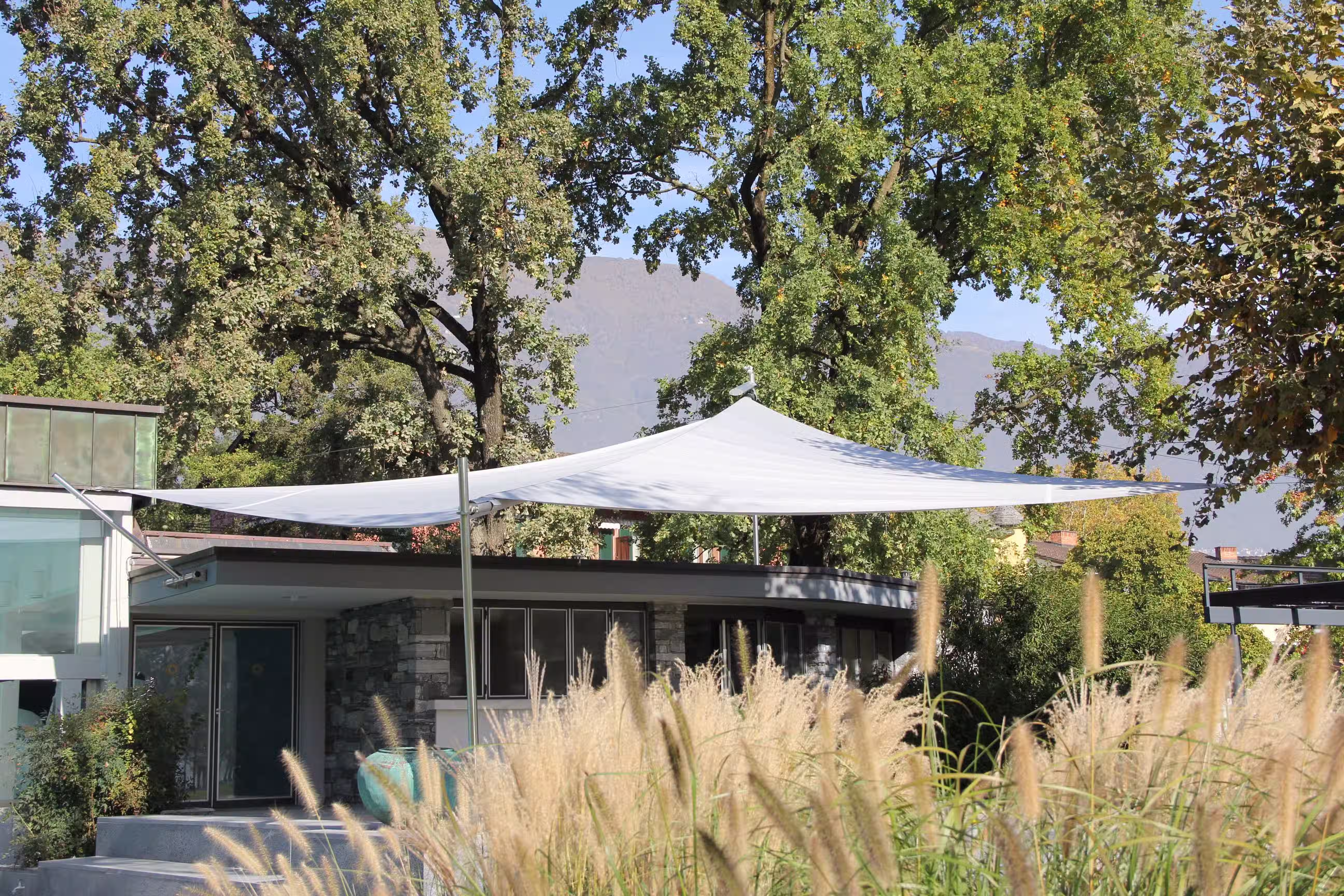 A view from afar of the sail of the Castello del Sole wellness resort in beautiful Ticino. The sail blends harmoniously into the outdoor area of the hotel.