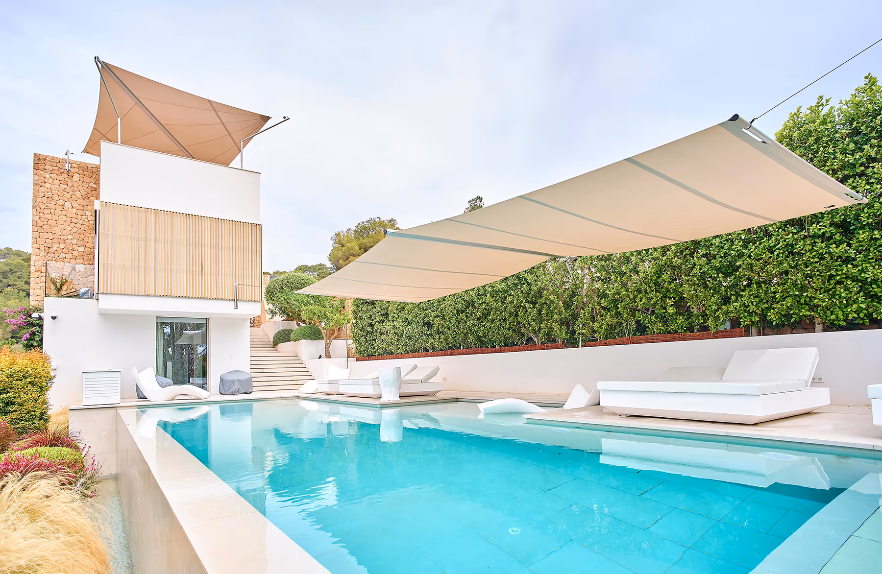 Due sistemi di tende da sole SunSquare: un sistema a triangolo sulla terrazza sul tetto e un sistema rettangolare AX-Cantilever sopra la piscina, con soli cinque punti di montaggio e un albero autoportante, perfettamente adattato alla stretta area di riposo, controllato in modo completamente automatico premendo un pulsante.