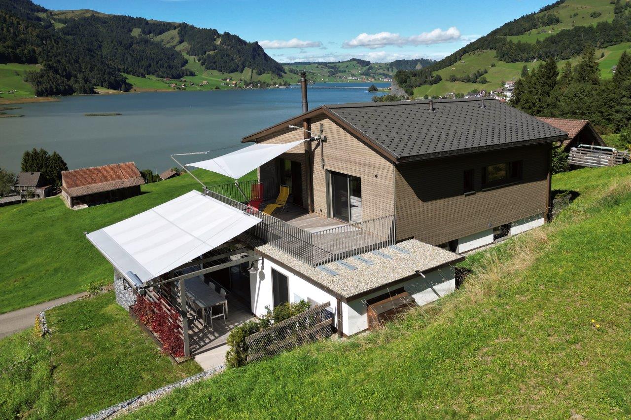 Eine Ansicht von der Seite zeigt das hübsche Wohnhaus mit den beiden SunSquare Sonnensegel-Anlagen.