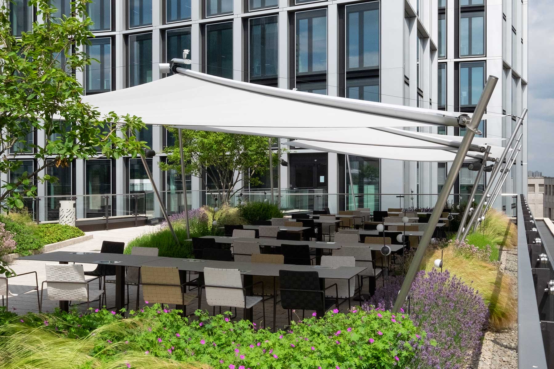 170 m² beschattete Terrassenfläche mit SunSquare Sonnensegeln über den Dächern Frankfurts.