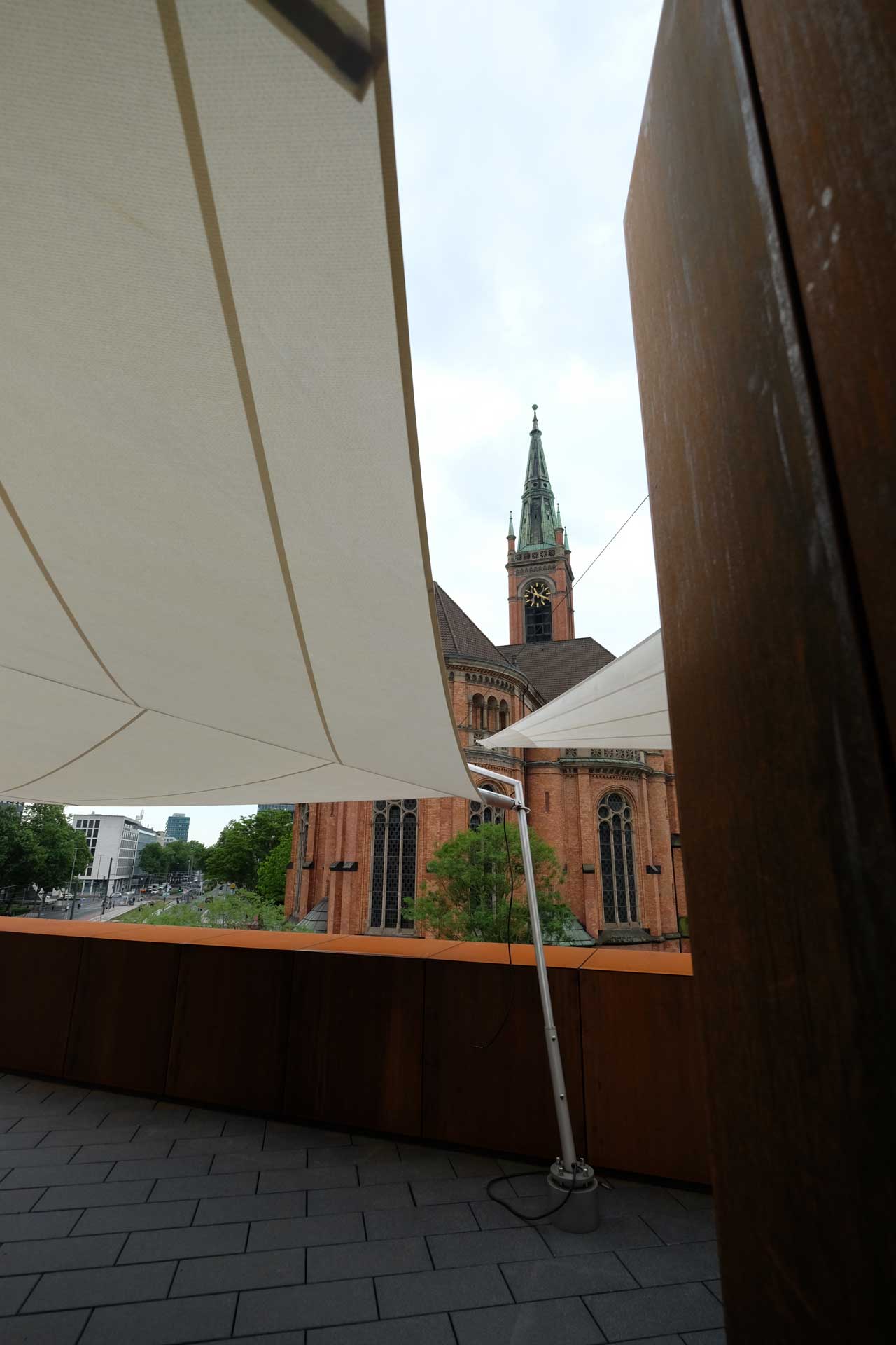 Moderne Außengastronomie mit großflächiger Sonnensegelanlage.