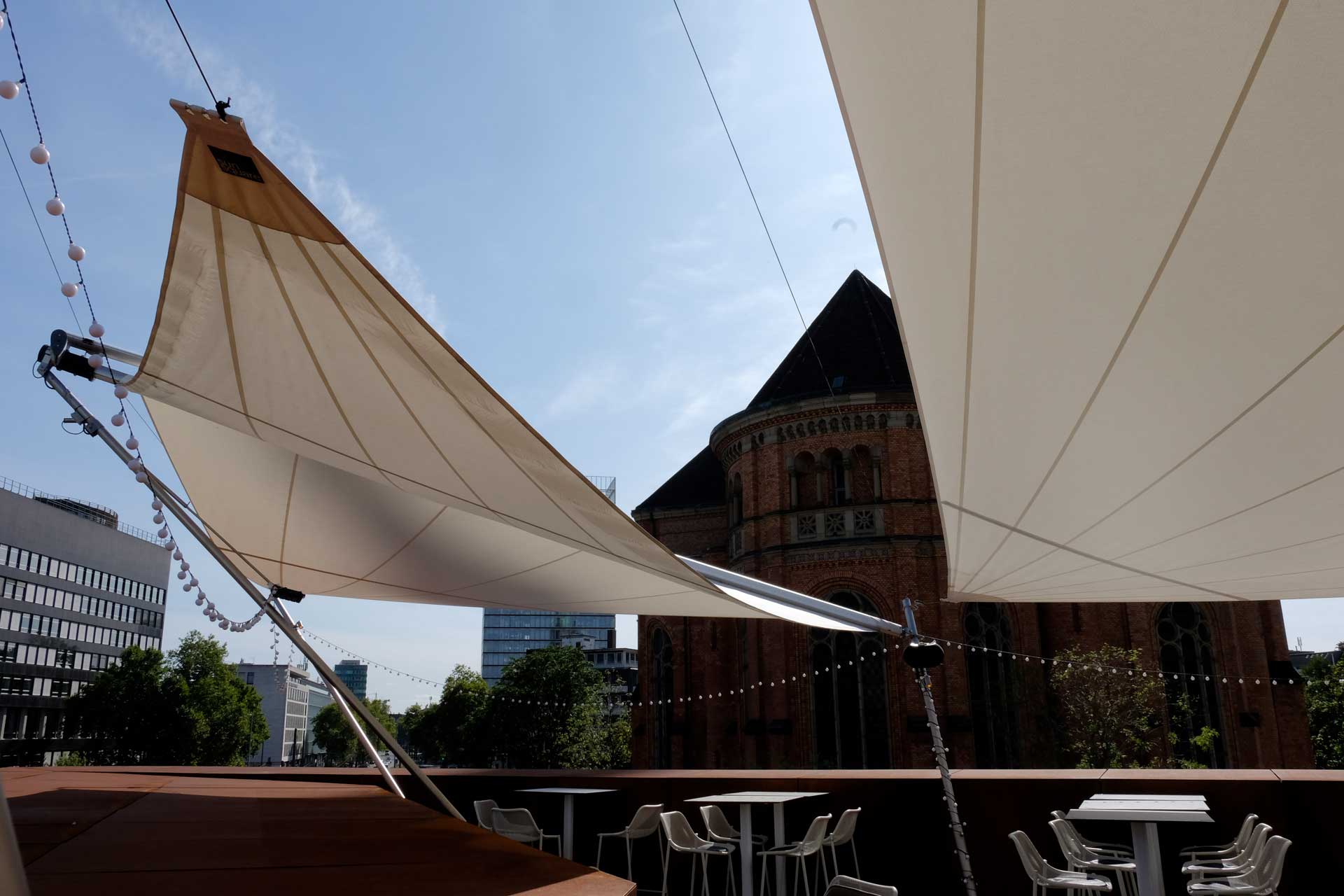 Großflächige Terrassenbeschattung für die Außengastronomie mit SunSquare Sonnensegeln.