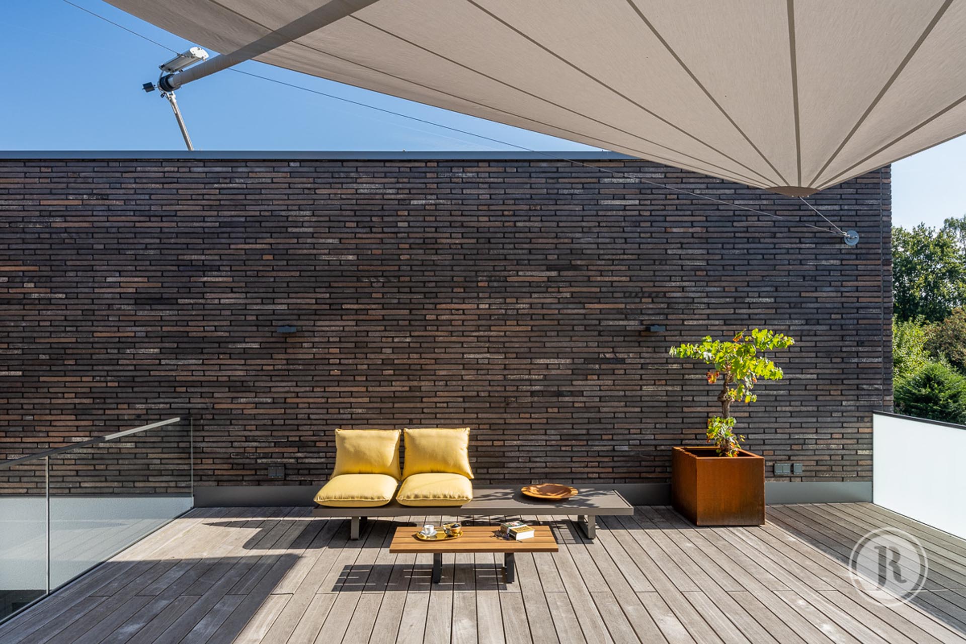 Großzügige Dachterrassenbeschattung mit SunSquare Dreieck-Sonnensegelanlage.