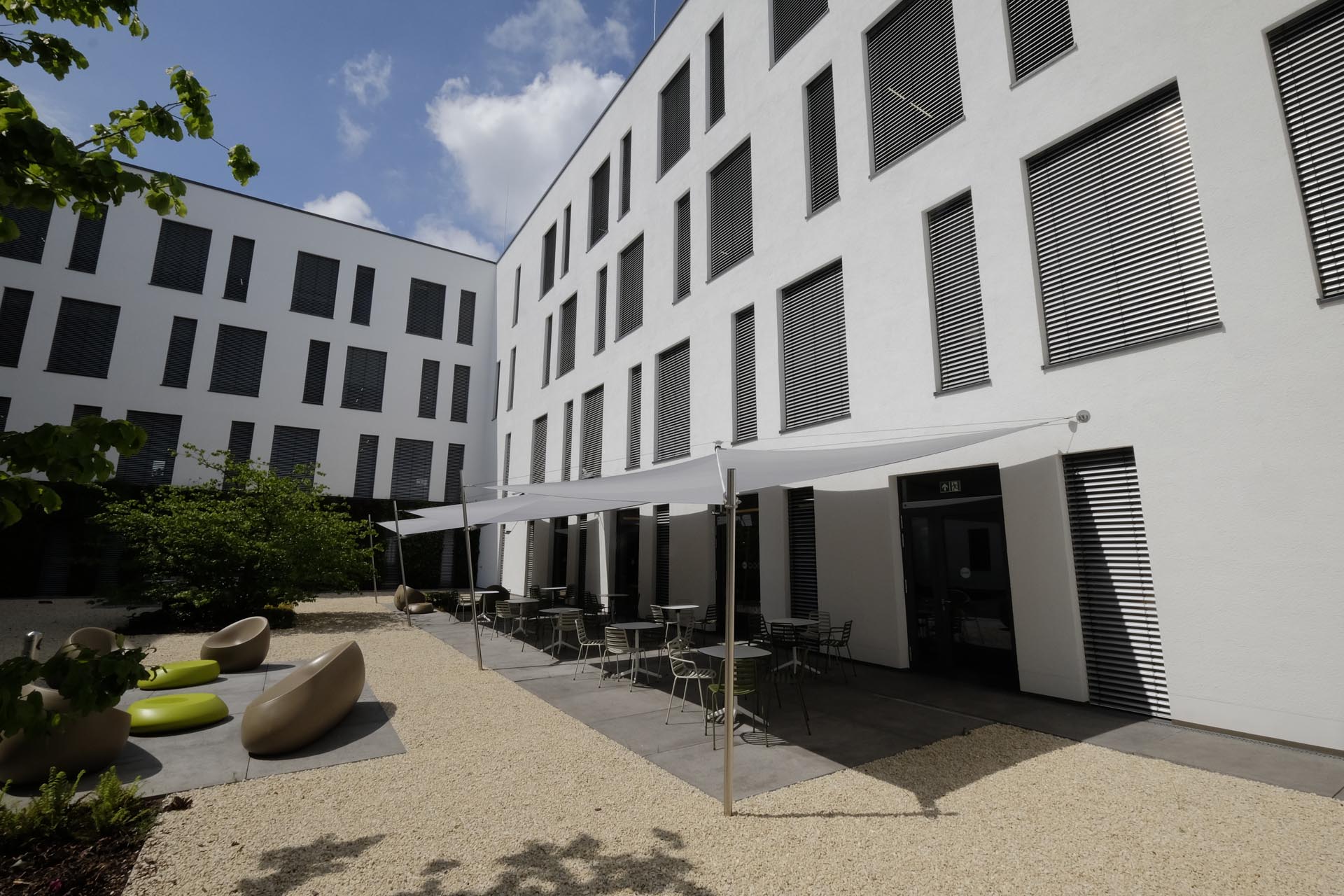 Klimafreundliche Gestaltung von Firmeninnenhöfen mit SunSquare Sonnensegeln.