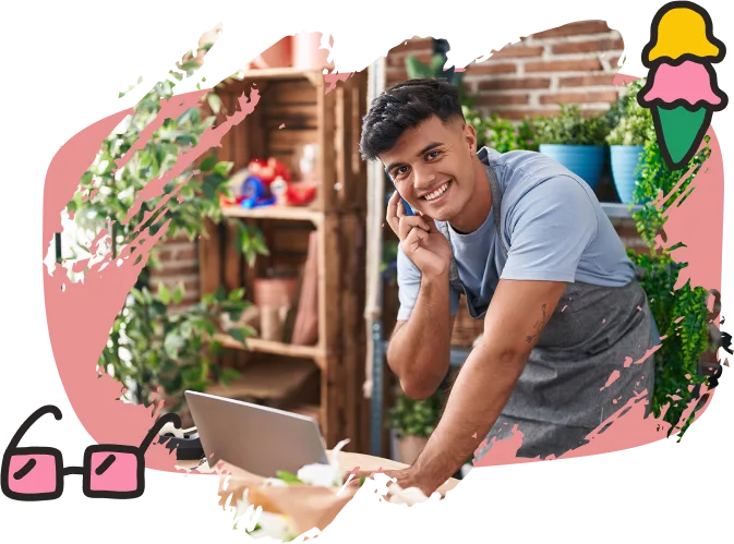 Young male shopkeeper in apron talking on the phone and smiling, standing by a laptop in a plant-filled store. Surrounded by playful illustrations of glasses and ice cream. Friendly, small business vibe.