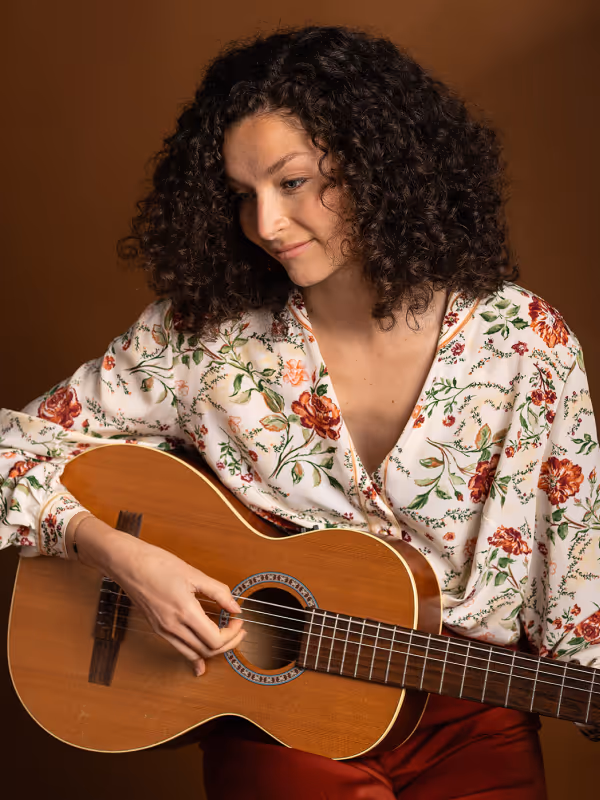 Photo de Claire Cyan, artiste musicienne et chanteuse avec une guitare à la main