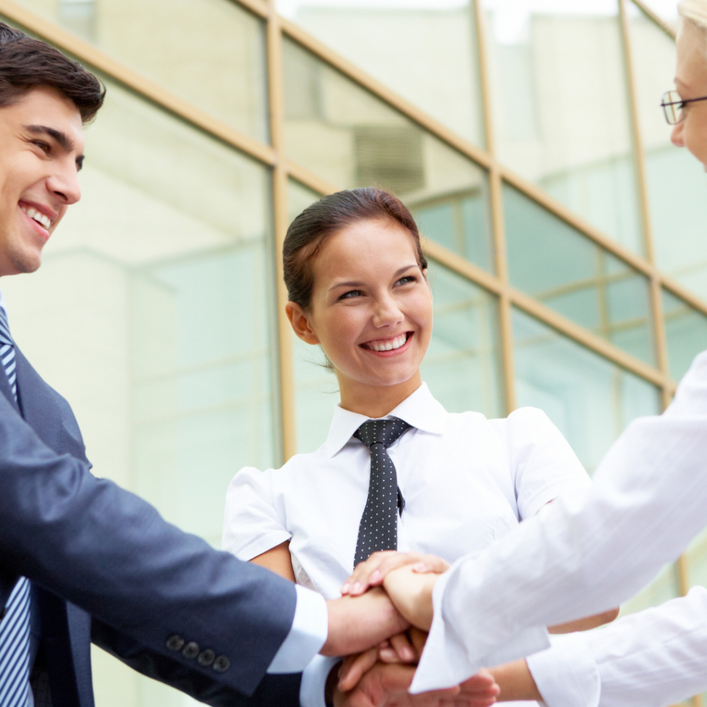 Business professionals shaking hands, smiling, and engaging in a collaborative atmosphere, representing accountability and teamwork in a corporate setting.