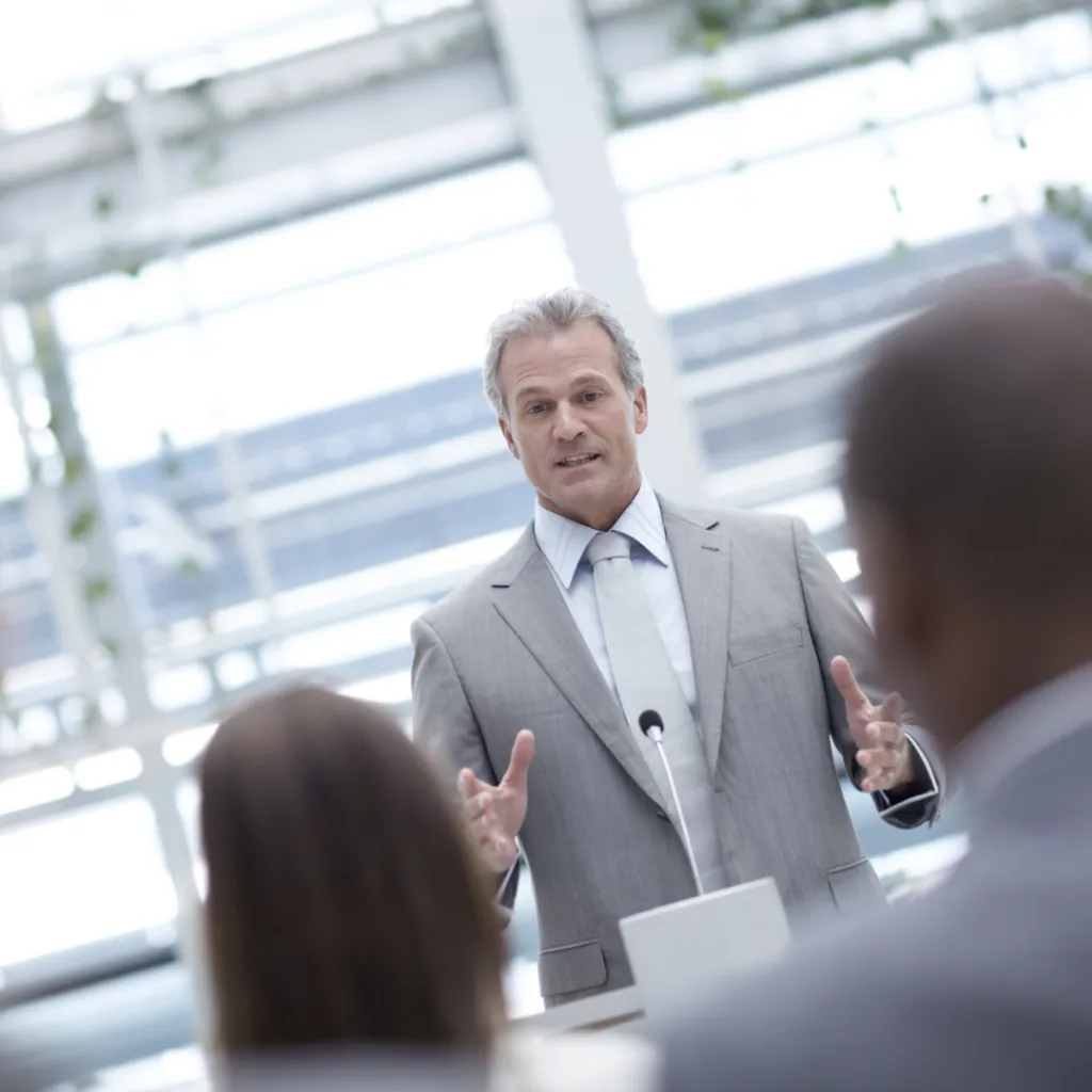 Business leader presenting to an audience, emphasizing accountability and leadership development in a corporate setting.
