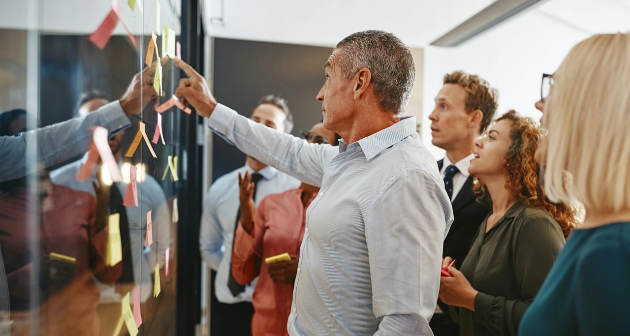 A professional team collaborating on a strategy board in an open office