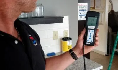 Digital ATP monitoring device displaying verified test results showing dramatic reduction in biological contamination after electrostatic disinfection treatment