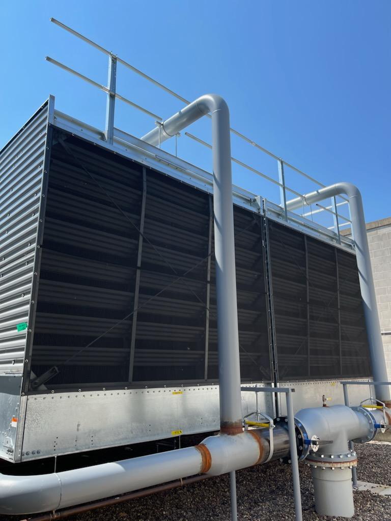 HVAC unit with black mesh prevent screens installed to protect against cottonwood and seasonal debris, reducing maintenance costs