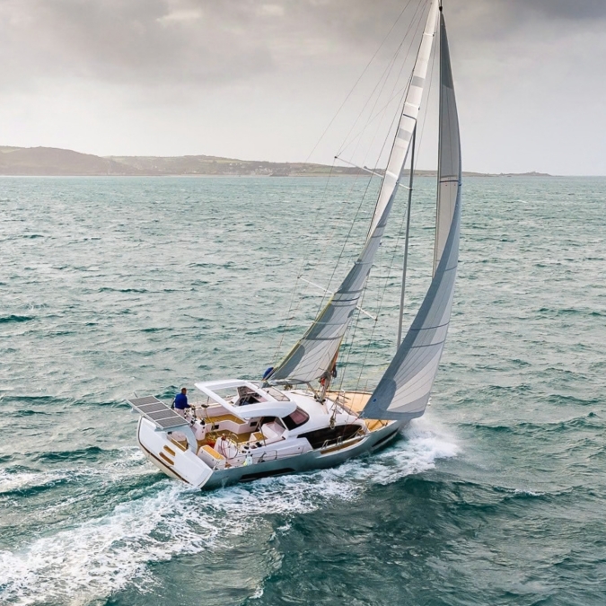 Aerial view of the Allures Horizon 47 under sail, showing the cockpit and wake.