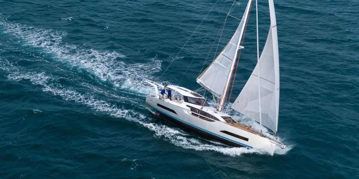Aerial bow-quarter view of the Allures Horizon 47 under sail, showing its aluminum hull and wake.