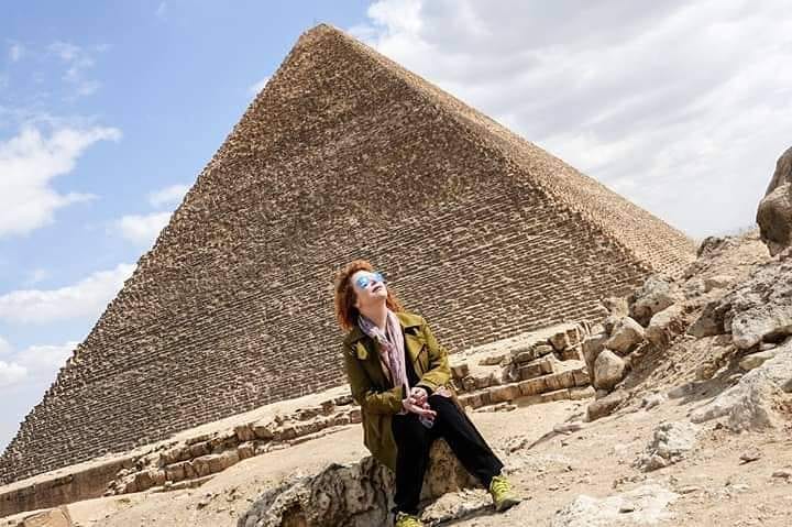 unge Frau mit Sonnenhut auf einer traditionellen Feluke auf dem Nil bei Luxor, entspannt und stilvoll bei Tageslicht