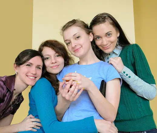 3 women smiling with a caregiver