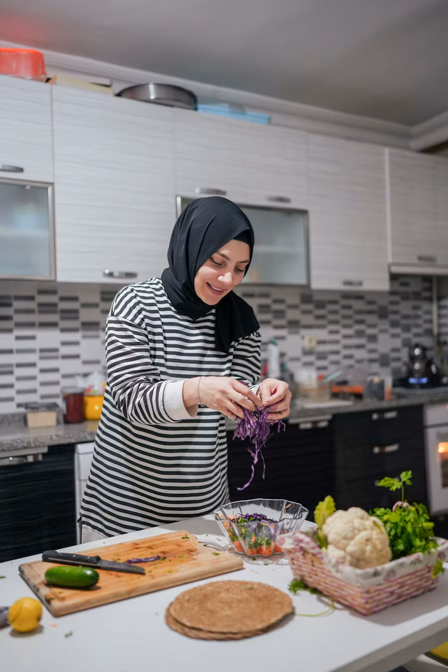 a woman standing in a kitchen preparing food