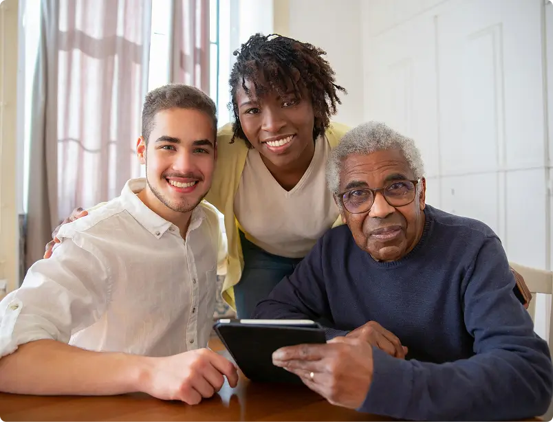 caregivers and elderly smiling and looking at the camera