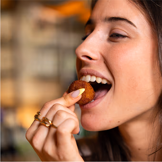 Cliente savourant une bouchée apéritive gourmande chez Trolls & Croque à Lille