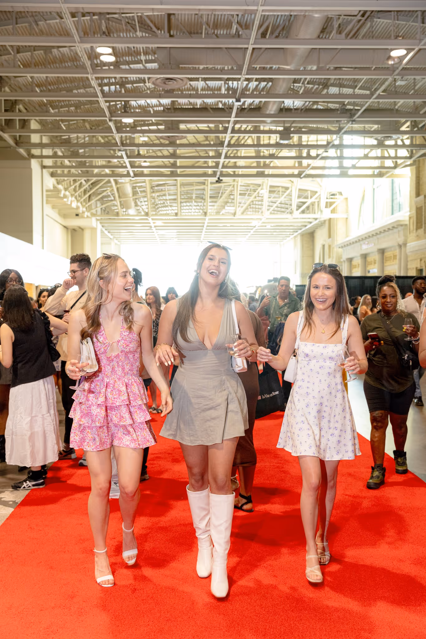 Three women walking atop a red carpet at Wine Fest Toronto