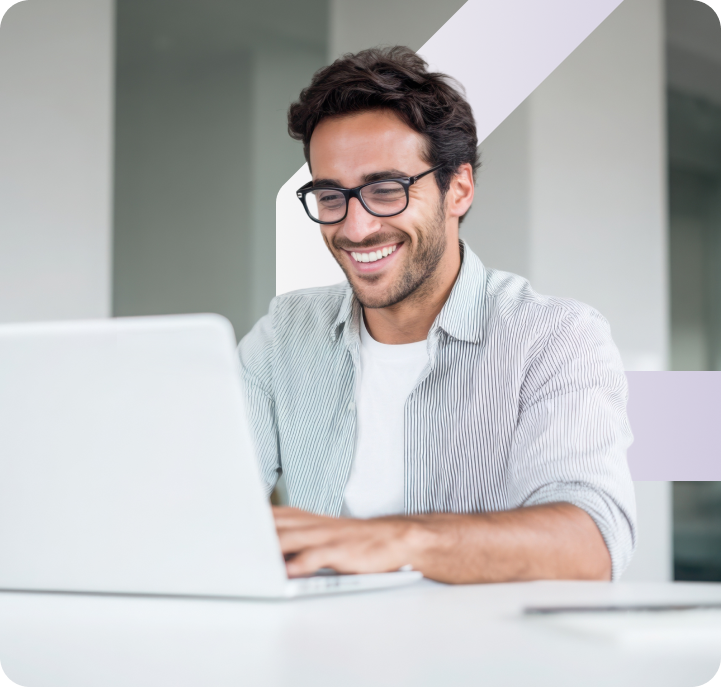 Smiling man using laptop, representing Micom’s multi-channel communication platform.
