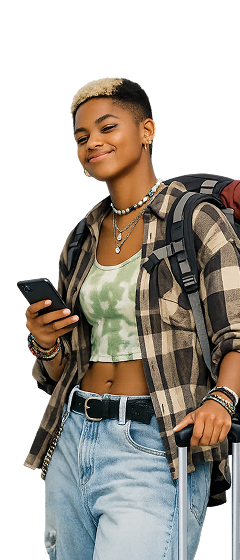 Smiling young person with short dyed hair wearing a plaid shirt, green tie-dye crop top, jeans, and a backpack, holding a smartphone and suitcase handle.