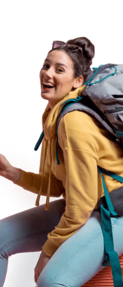 Smiling woman wearing a yellow hoodie with a bun hairstyle carrying a large gray backpack.