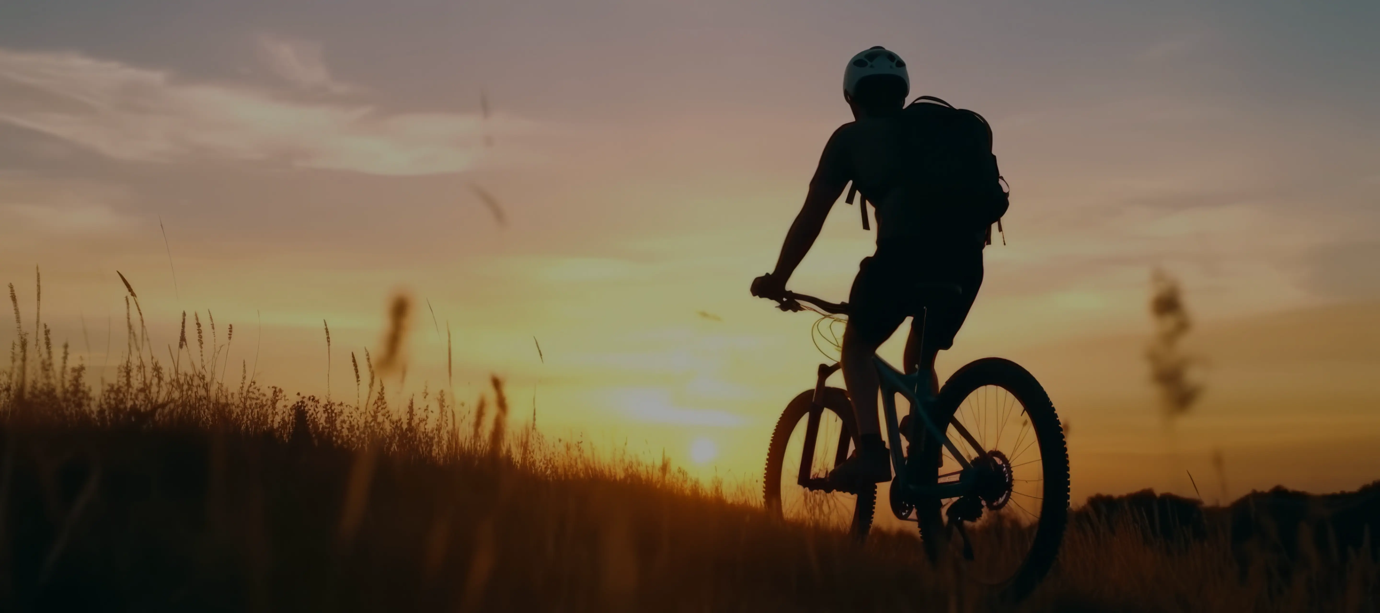 A man riding a bike on top of a grass covered field