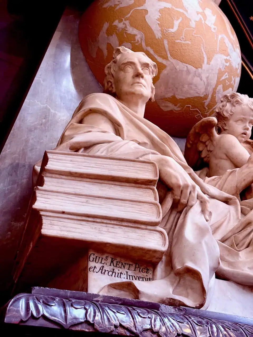 Classical statue holding book with cherub beside it