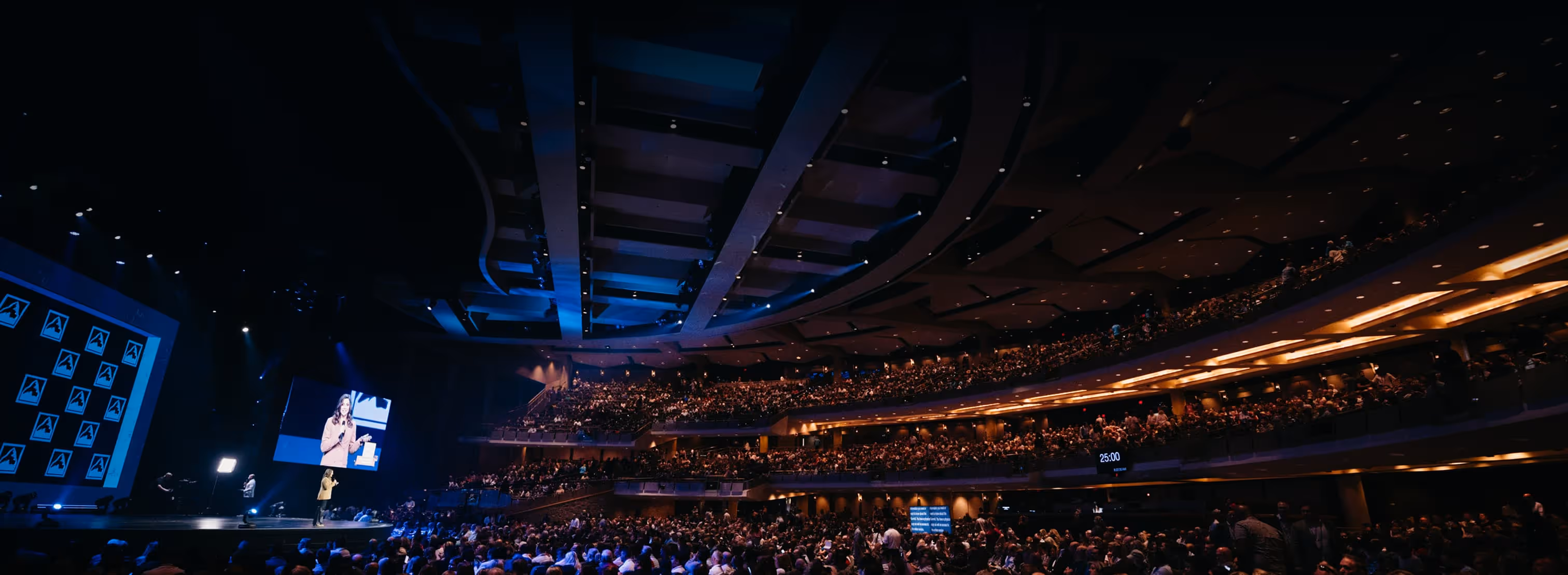 Large congregation showing woman teaching on large screen