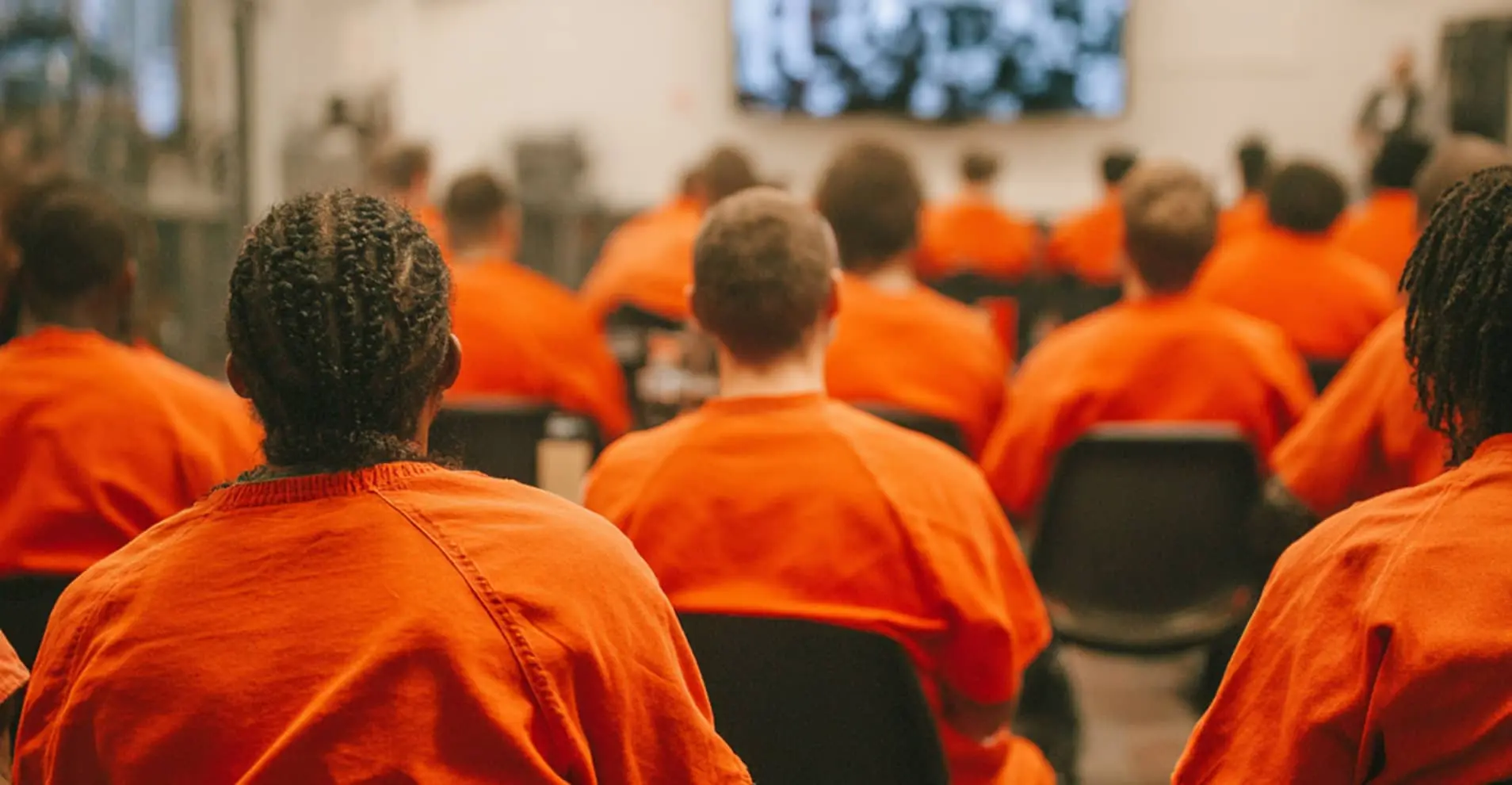 Men in prison enjoying church on a screen