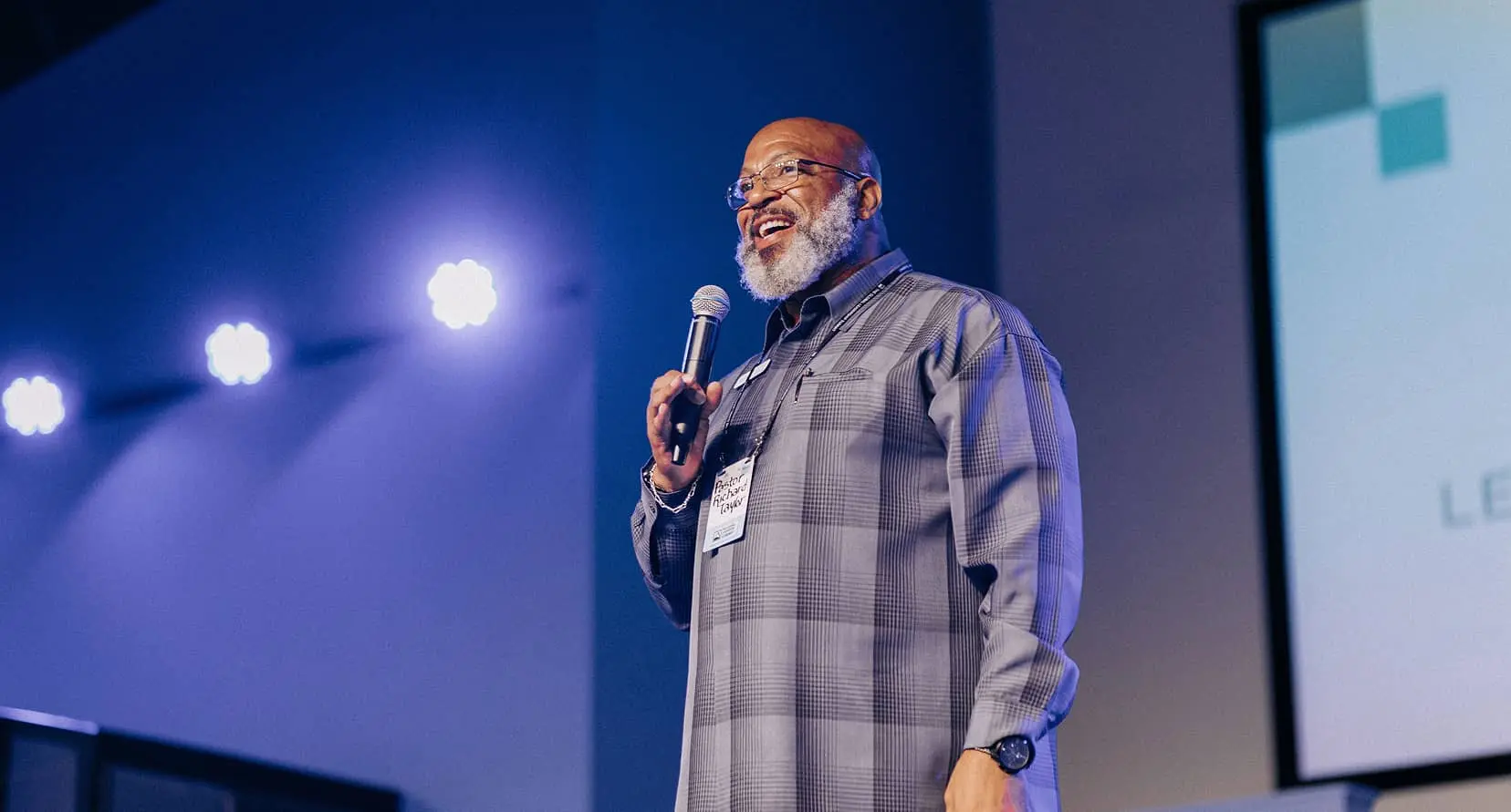 Man wit beard speaking on stage