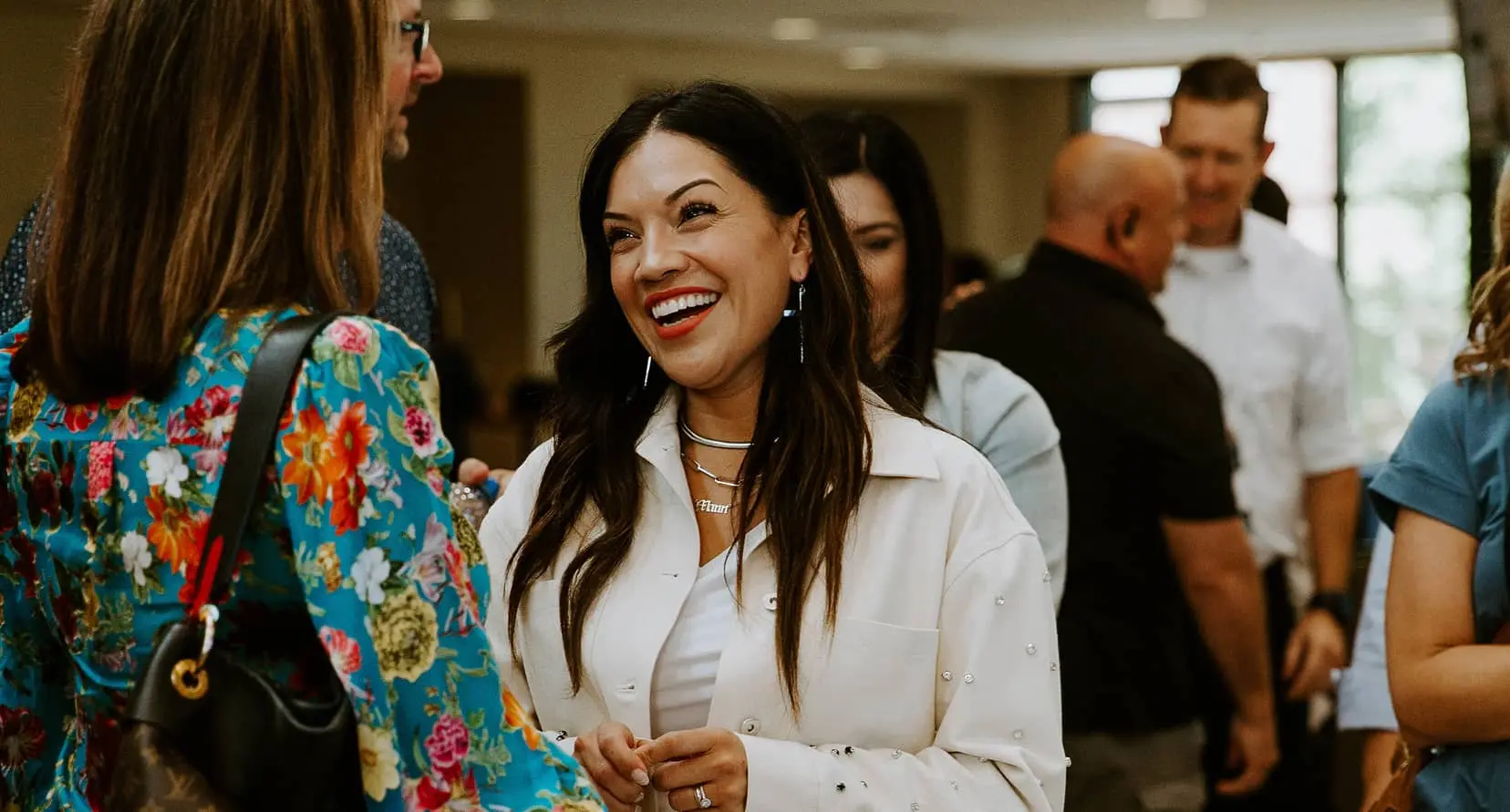Woman smiling and having a conversation in an open meeting area.