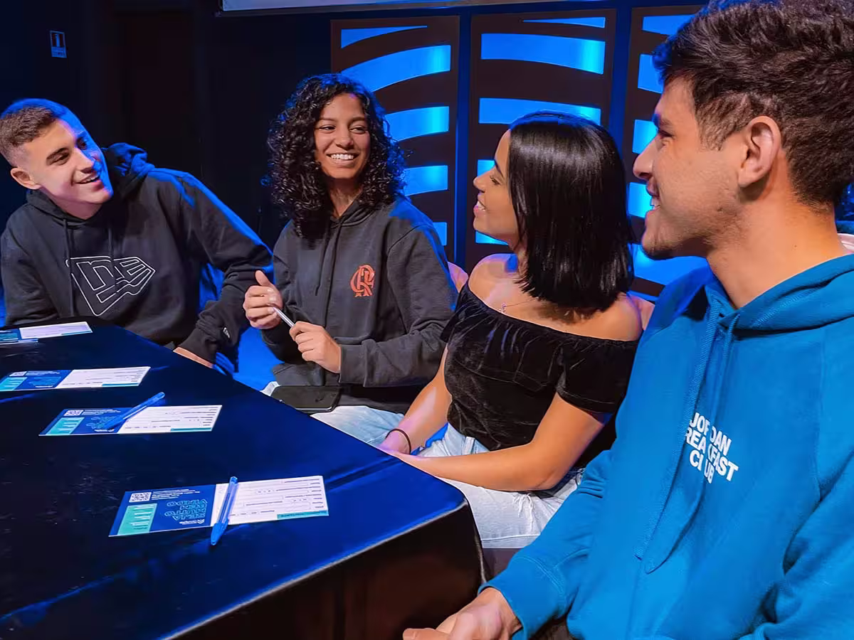 Group sitting and having discussion at a table with blue glossy table cover