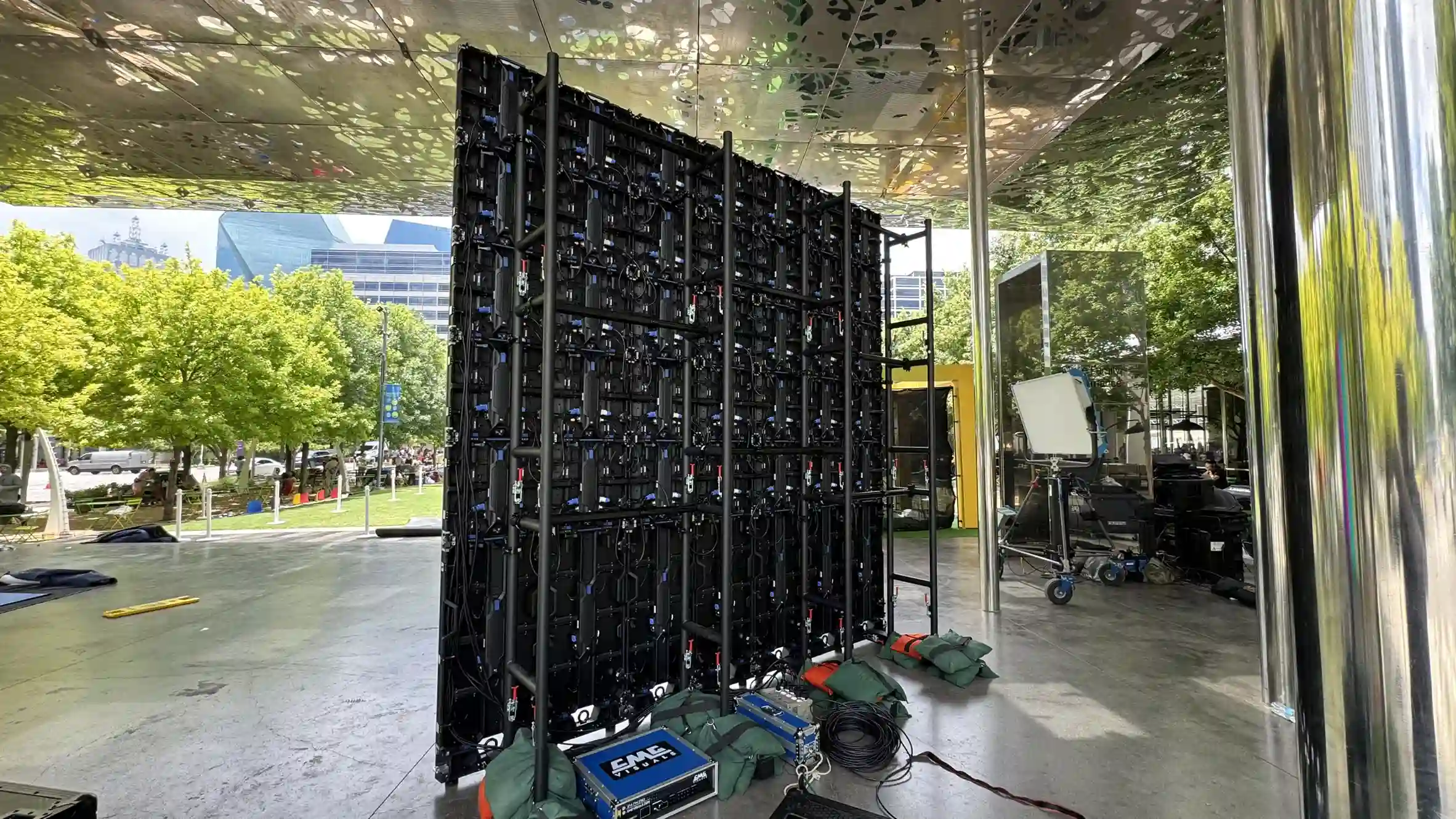 Back of an LED video wall screen underneath a canopy that is outdoors.