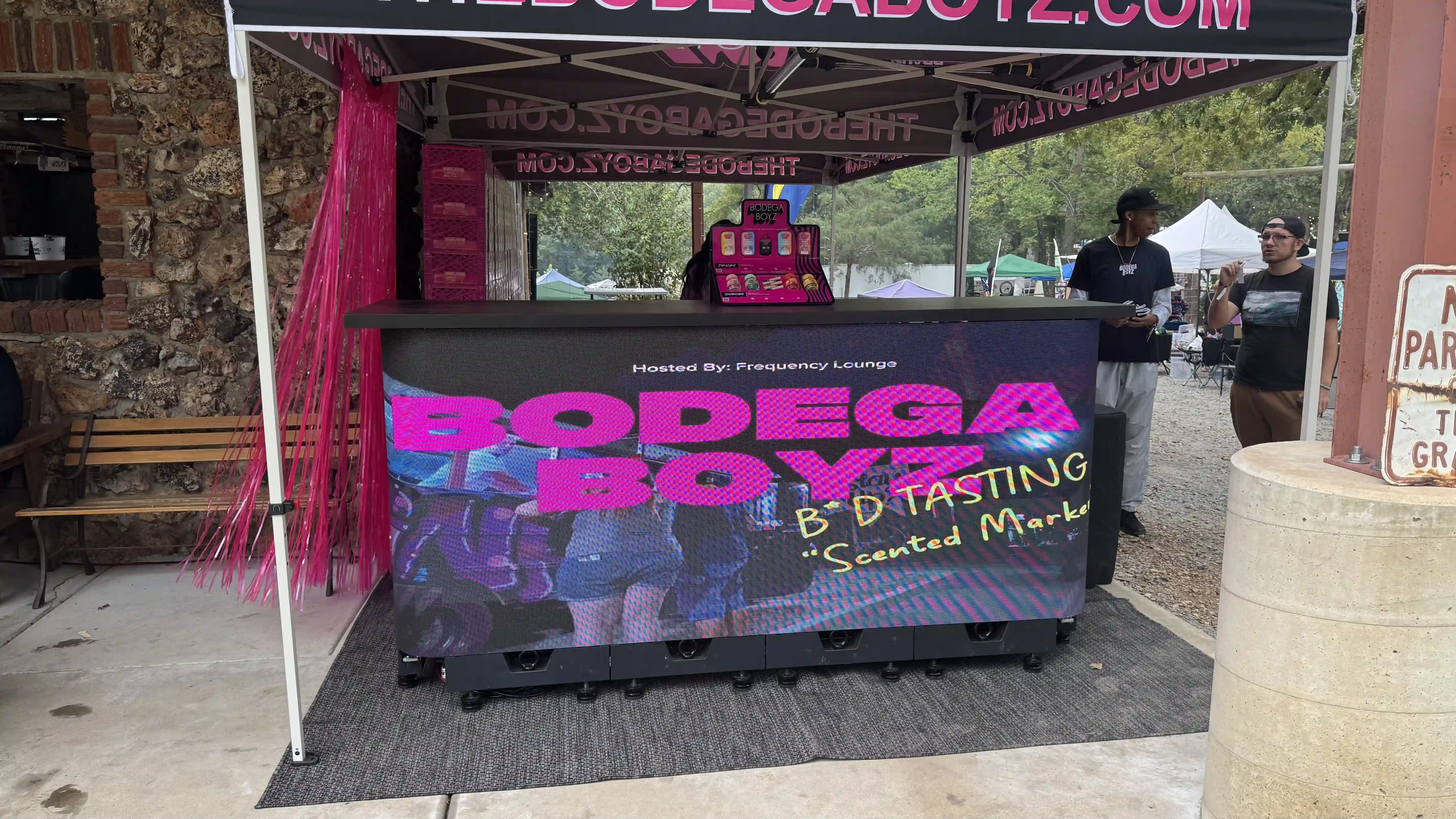 LED DJ booth rental by CMG Visuals for the Bodega Boyz event, featuring bright custom graphics displayed outdoors under a branded canopy.