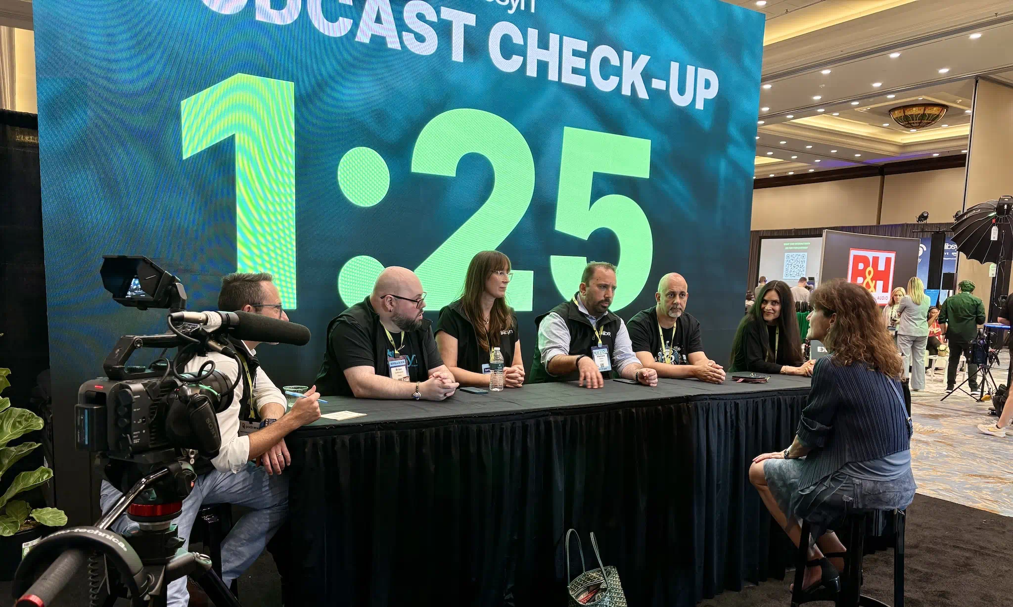 Large LED video wall used as a backdrop for a live broadcast panel at a trade show event.