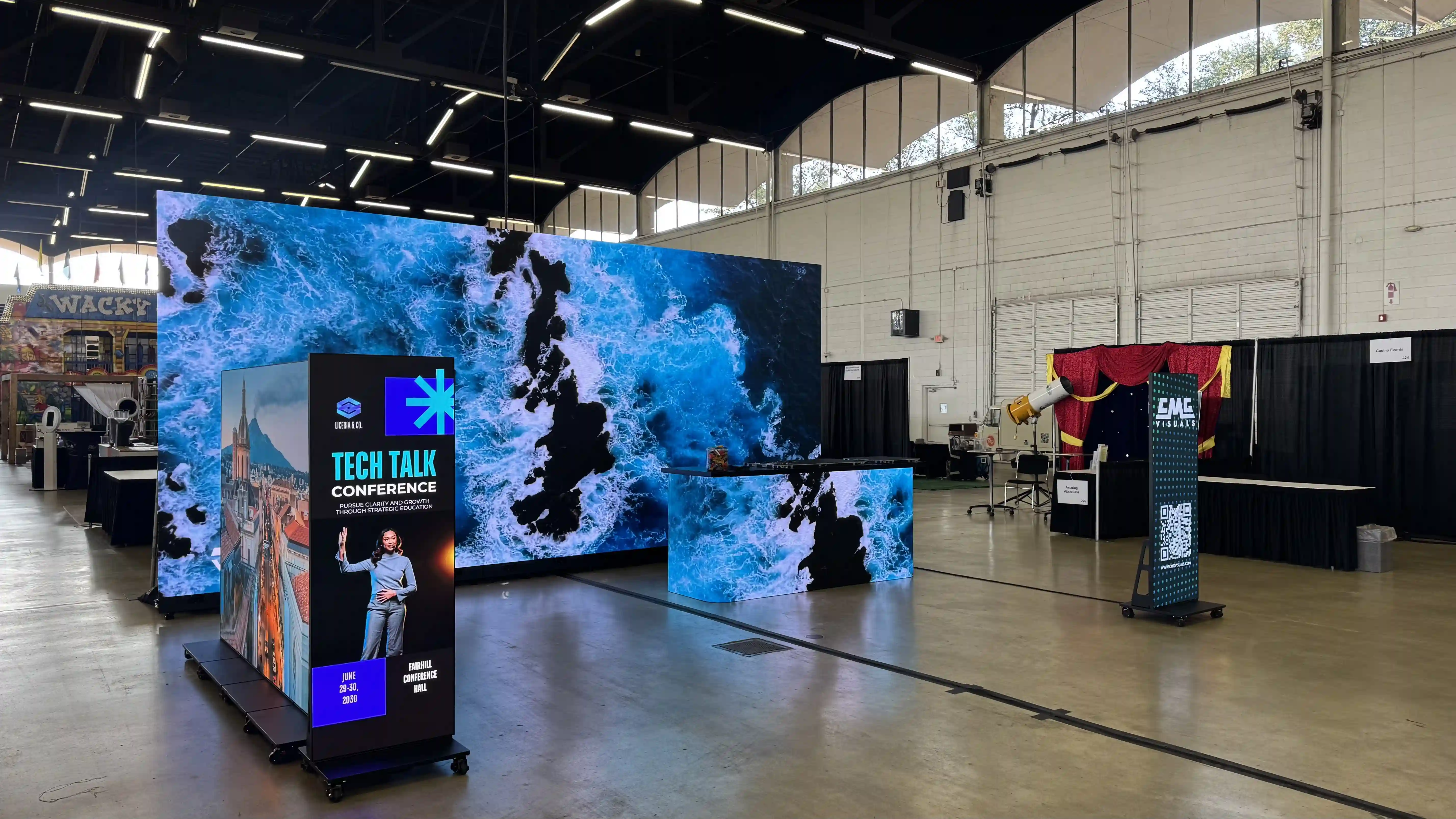 Tradeshow setup of large LED Screen with posters in the foreground.