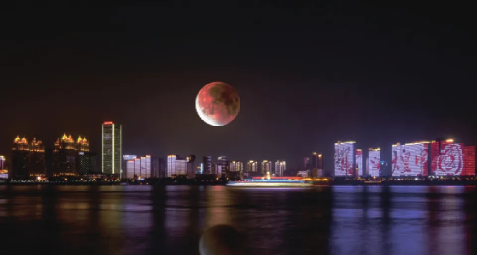 Night cityscape with a lunar eclipse on a competitor LED panel, with shadow detail lost to crushed blacks