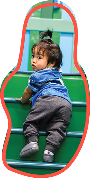 Small toddler-aged child climbing stairs during a pediatric therapy session